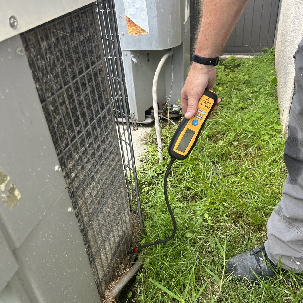 Refrigerant leak check on a rental's AC system